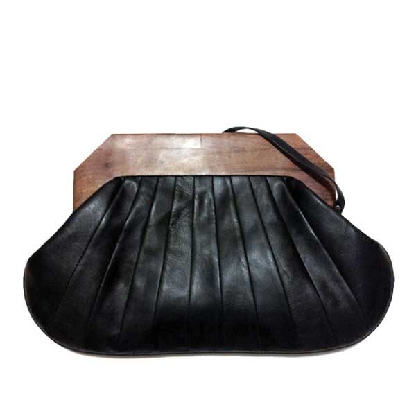 Origami clutch in black leather. Teak wood handle and leather strap. Exterior design has a folded leather look.