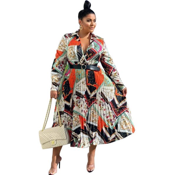 Model wearing a long-sleeved pleated multi-colored dress with black belt.